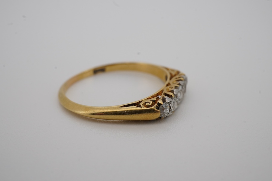 An early 20th century yellow metal and graduated five stone diamond set half hoop ring, size N, gross weight 2 grams. Condition - fair